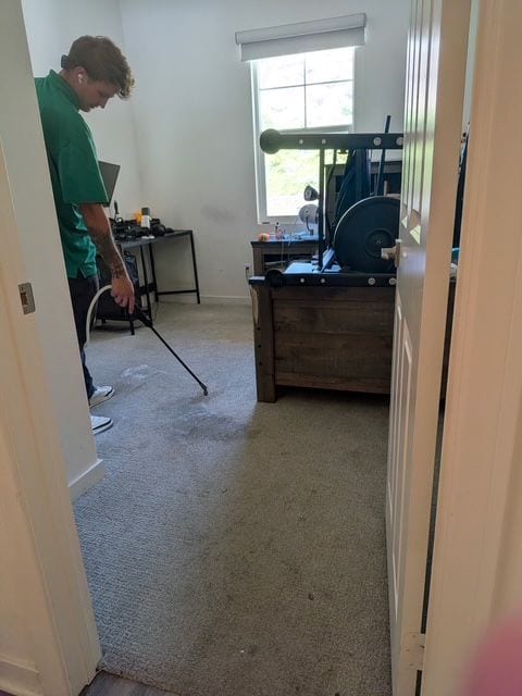 Technician pre-treating carpet during a residential cleaning job
